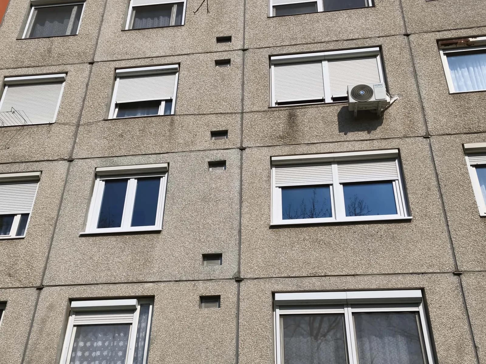 Szigetelt győri panelház homlokzata a felújított ablakokkal